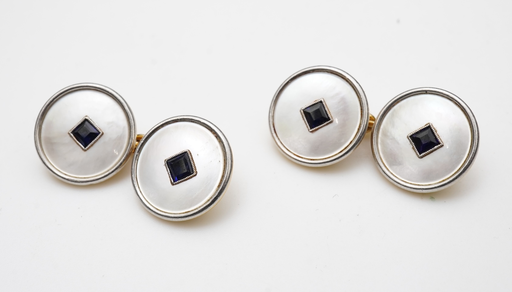 A pair of mother of pearl and sapphire cufflinks, early 20th century